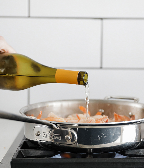 Shrimp in pan with wine bottle