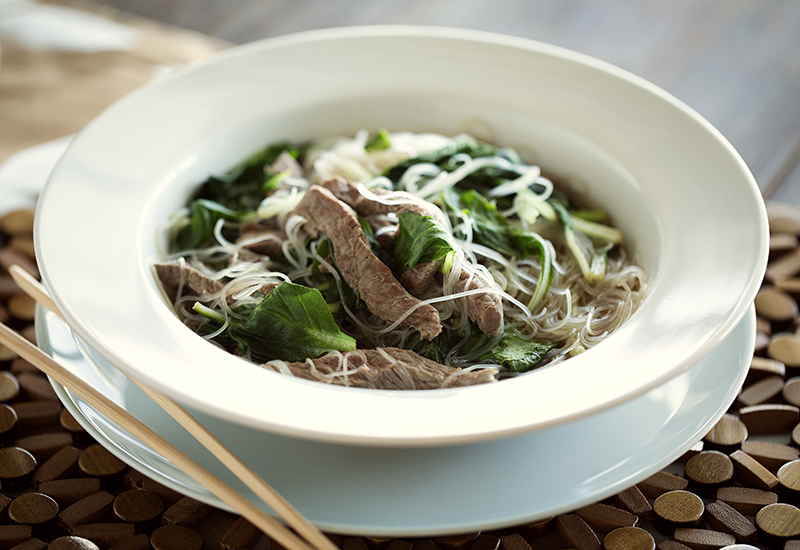 Beef pho in white bowl