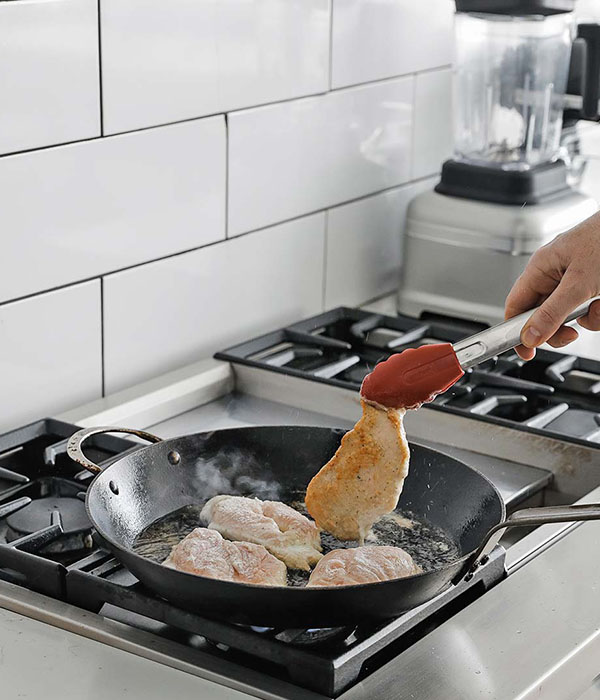 Cooking chicken in a pan with spatula