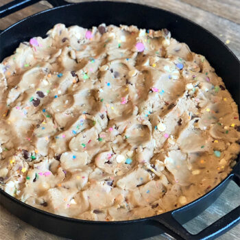 Baked skillet cookie in cast iron pan before slicing