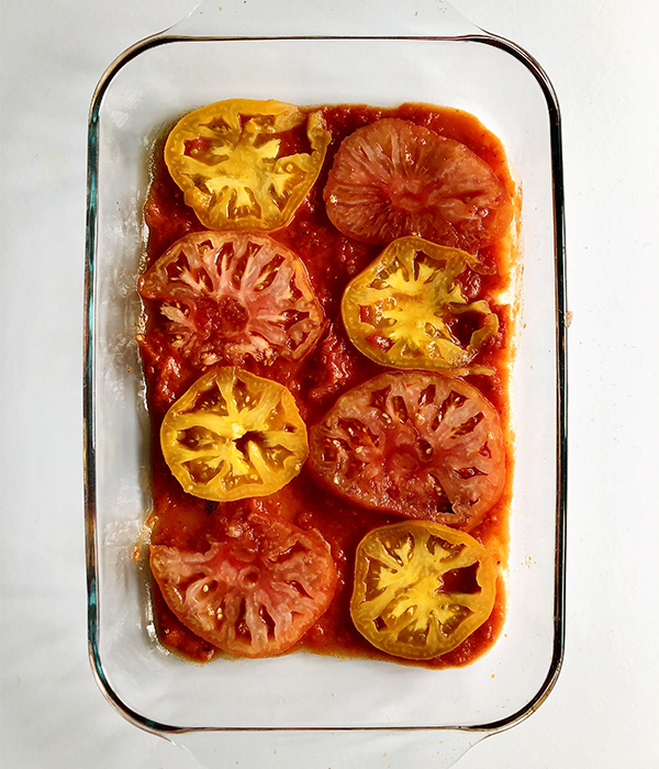 Frozen Ravioli Lasagna, sliced tomatoes on the bottom of pan