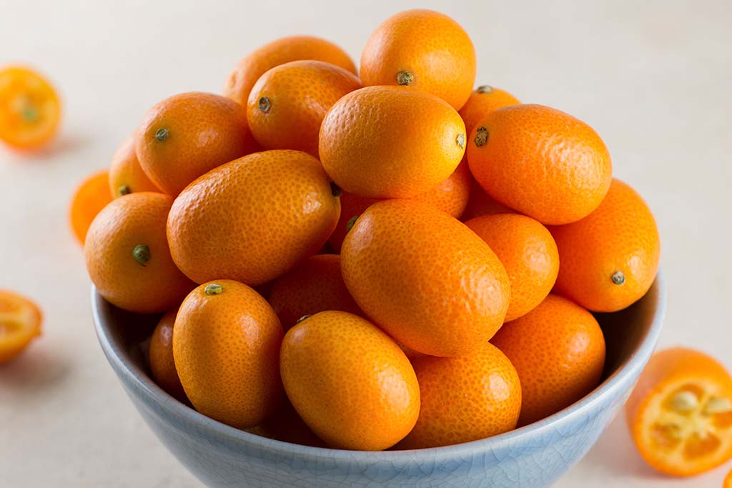 Kumquat stacked in a bowl.