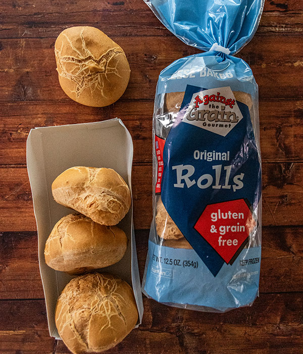 Against the Grains Frozen Rolls Package on a Wood Surface with Warmed Rolls