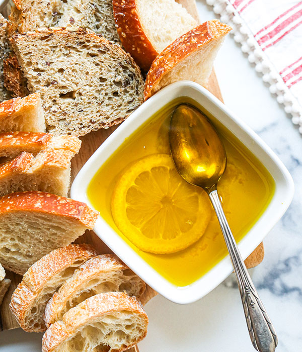 Extra Virgin Olive Oil in a Serving Bowl with a Lemon Slice and Bread