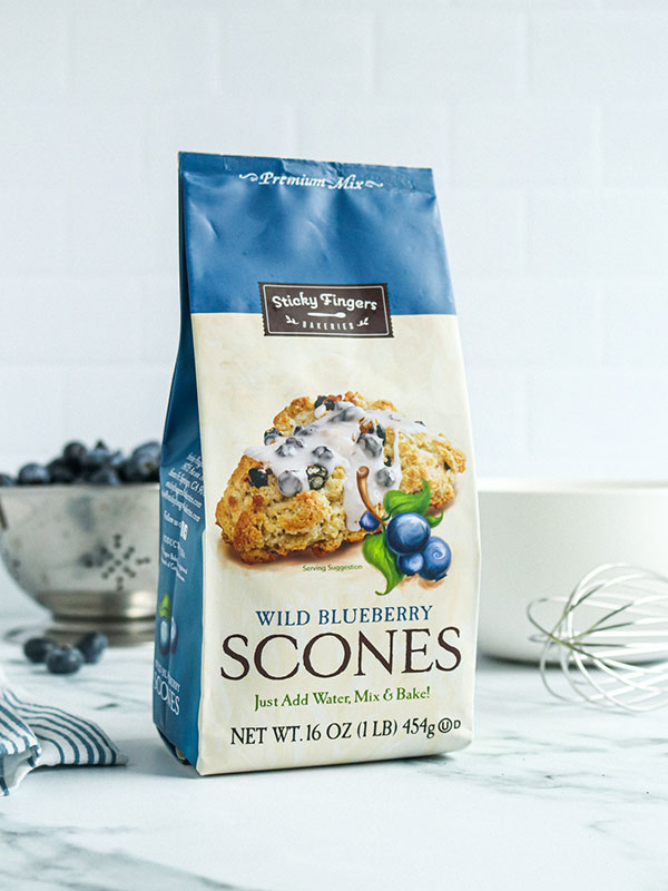 Sticky Fingers Wild Blueberry Scone Mix Beside a Colander with Fresh Blueberries