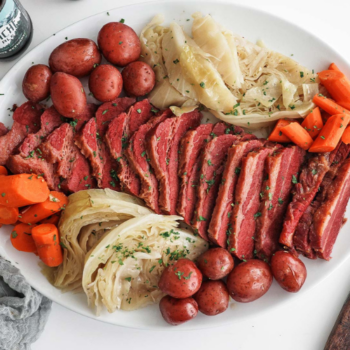 Cut up Corned Beef with sliced carrot and cabbage on a plate