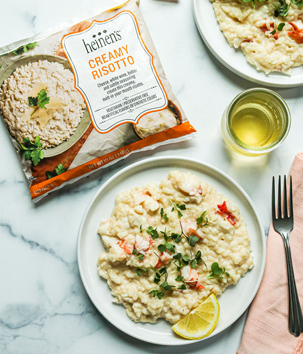 Easy Lobster Risotto on a Plate with a Glass of White Wine and a Bag of Heinen's Frozen Creamy Risotto
