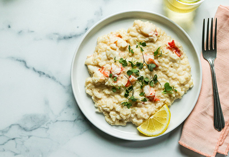 Easy Lobster Risotto on a Plate with Fresh Lemon and a Glass of White Wine