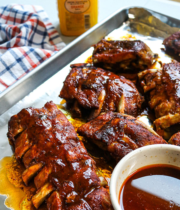 Slow Cooker Citrus BBQ Ribs on a Platter with BBQ Sauce