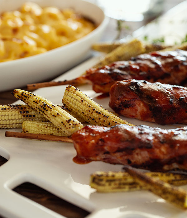 Close Up Vertical Image of Chicken Bacon Twisters on a Platter with a Bowl of Mac and Cheese