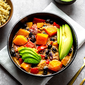 A Bowl of Black Bean Butternut Squash Stew on a Stone Background