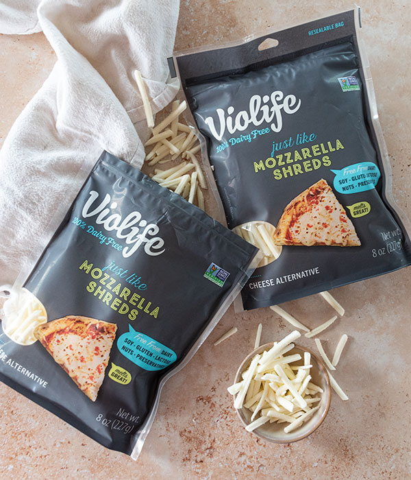 Violife Mozzarella Shreds Package and Fresh Mozzarella Shreds on a Neutral Surface White Dish Towel