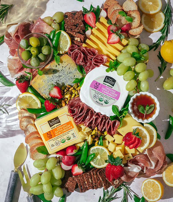 Heinen's Organic A2 Cheeses on a Cheeseboard with Fresh Fruit, Vegetables, Crackers and Fruit Spreads
