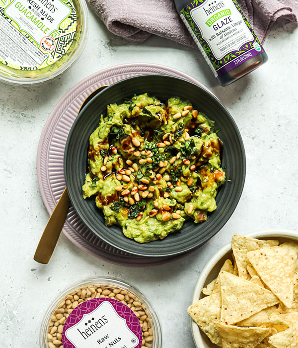 A Bowl of Guacamole with Fresh Basil, Balsamic Glaze and Pine Nuts on Top